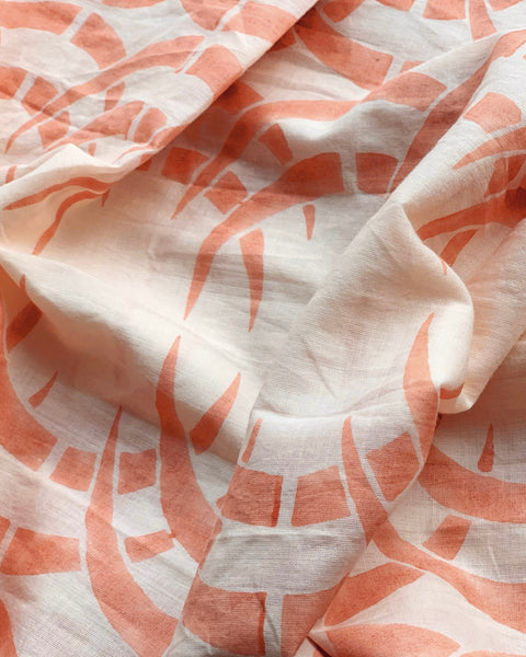 Close-up of a peach-colored wrap skirt with a rhino and horn pattern