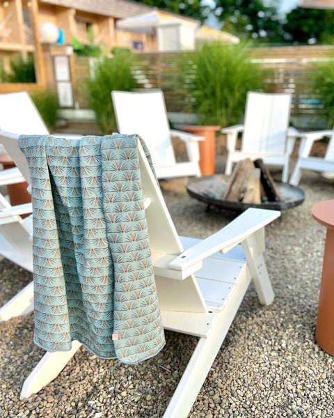 Light blue cozy wrap on adirondack chair at firepit
