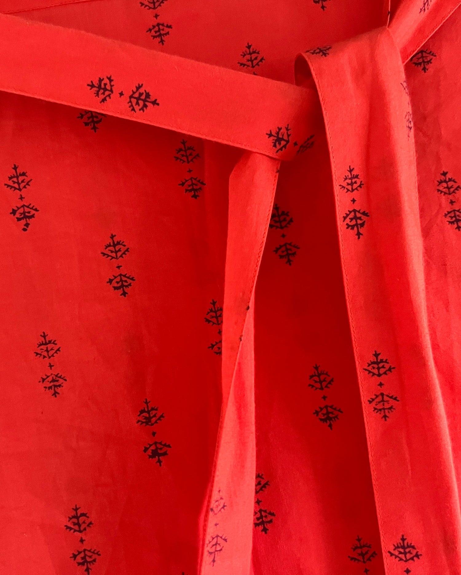Close-up of a red dress with puff sleeves and sash belt