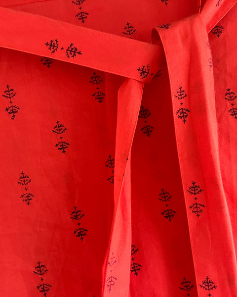 Close-up of a red dress with puff sleeves and sash belt