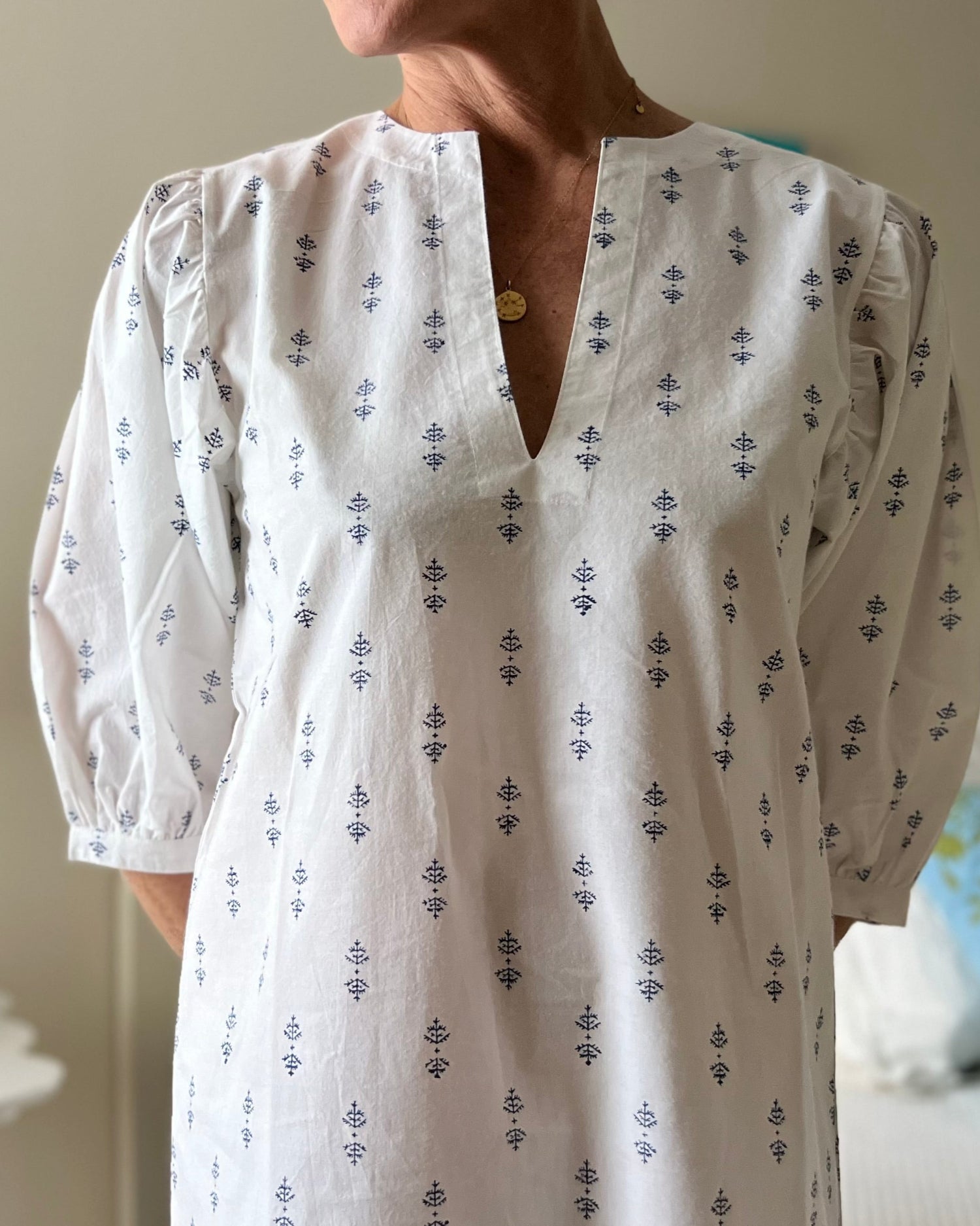 A woman wearing a white puff sleeve dress with blue print