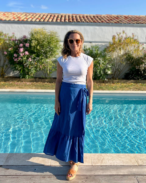 Woman in a royal blue hand block-printed maxi skirt standing next to a pool