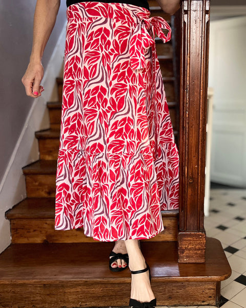 Woman wearing beautiful red and purple block-printed wrap skirt with ruffle on stairs