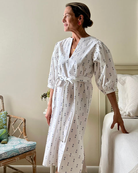 A woman wearing a white puff sleeve dress with blue print