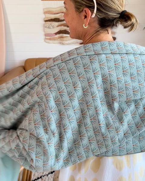 Woman wearing light blue cozy wrap/scarf 