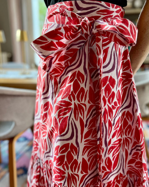 Woman wearing beautiful red and purple block-printed wrap skirt with big bow