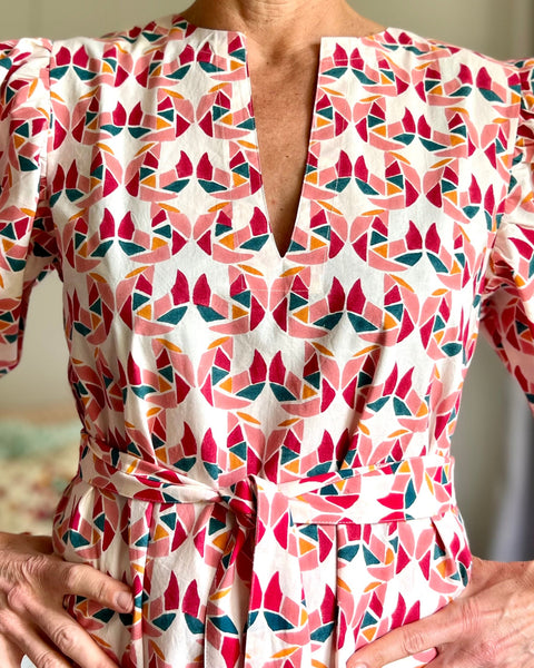 Woman in a multi-colored block printed puff sleeve dress standing 