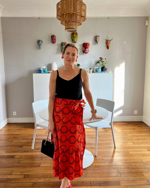 A person wearing a red and purple geometric patterned skirt with a wrap-around style.