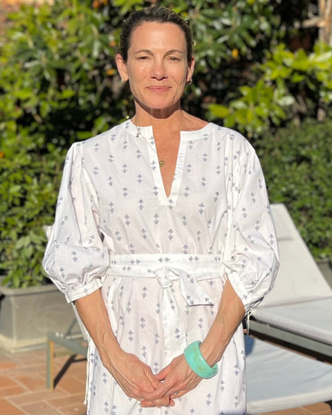 A woman wearing a white puff sleeve dress with blue print