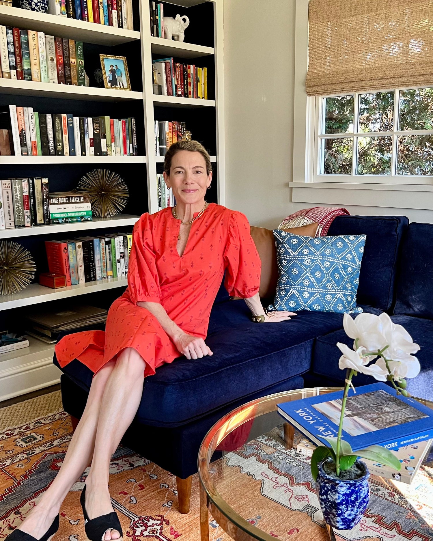 A person wearing a red dress with puff sleeves on a blue couch