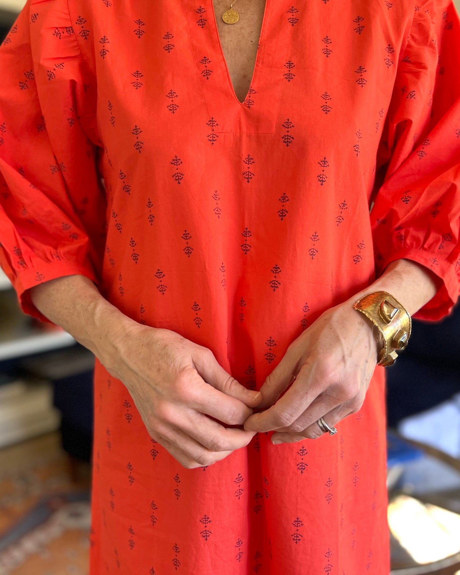 A person wearing a red dress with puff sleeves 
