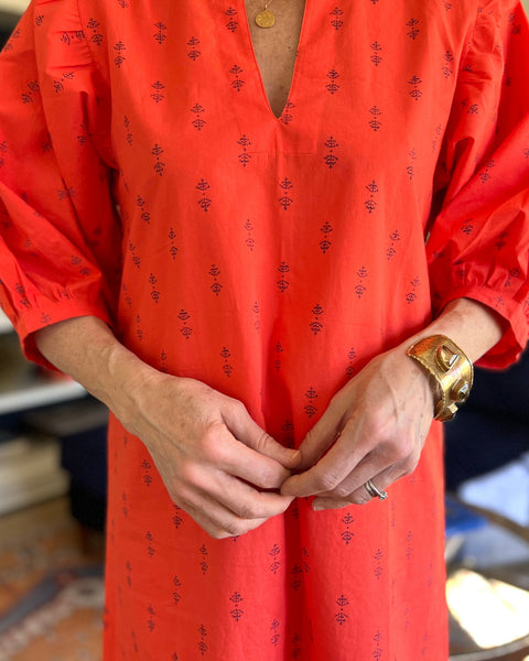 A person wearing a red dress with puff sleeves 