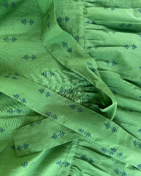 Close-up of green hand block-printed maxi skirt with ruffle and long waist tie