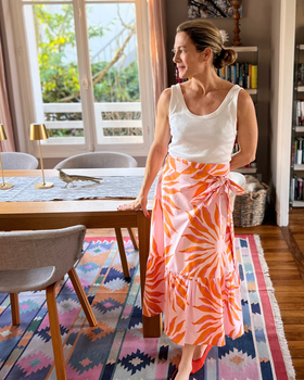 Woman wearing pink and orange wrap skirt with a ruffle at the bottom