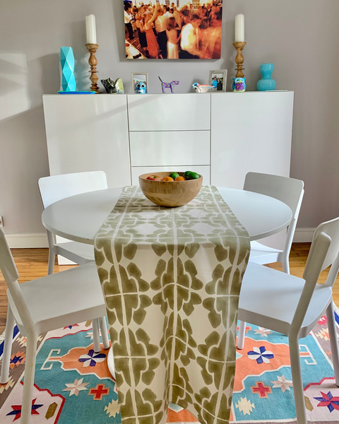 Wooden bowl with fruit on a hand block-printed sand / khaki and cream table runner in a sunny dining room