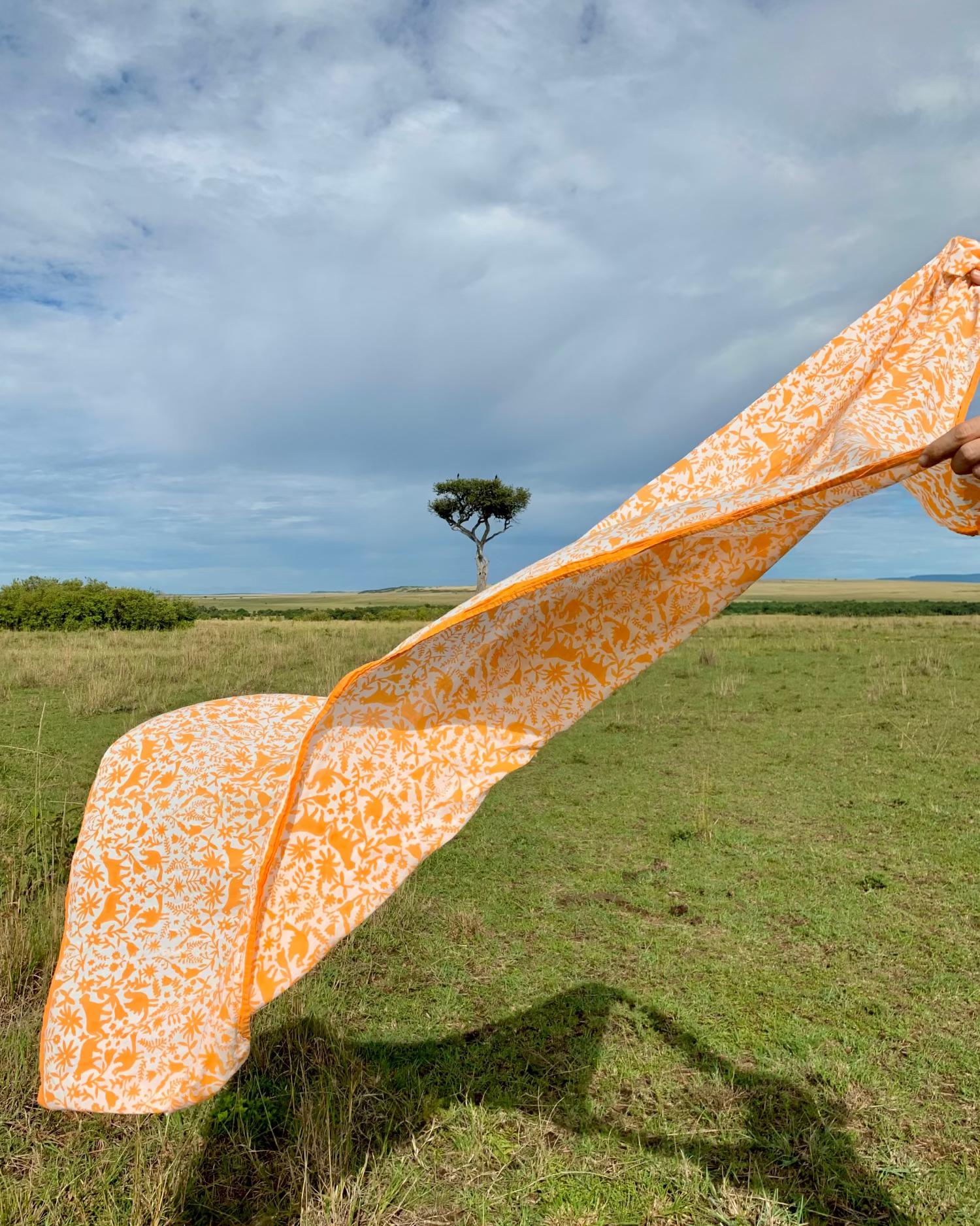 Orange hand block-printed jaguar sarong / grand scarf floating in air in Africa