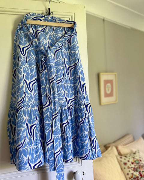 Blue and white hand block-printed wrap skirt with ruffle on hanger in a bedroom