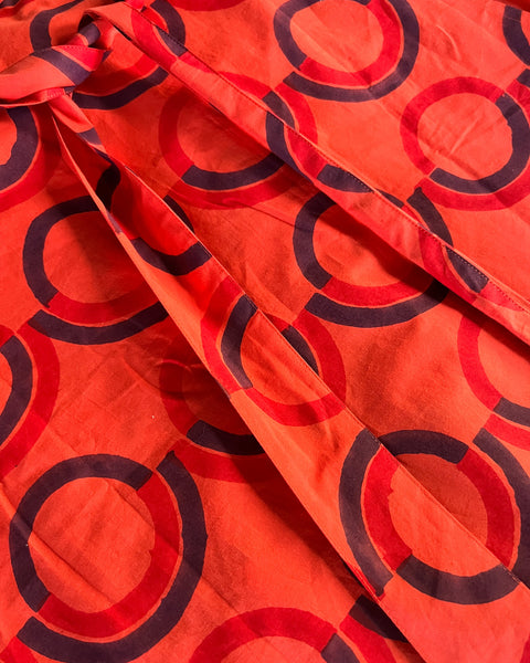 Close-up of a red and purple geometric patterned skirt with a wrap-around style.