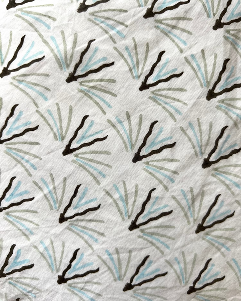 Close-up of an olive green, gray, and blue geometric patterned wrap skirt 