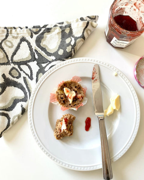 Gray, khaki, and white hand block-printed wild dog napkin with a muffin, butter, and jam