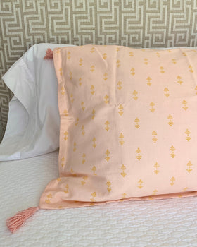 Organic cotton linen hand block-printed blush pink pillow sham with tassels on luxurious bed