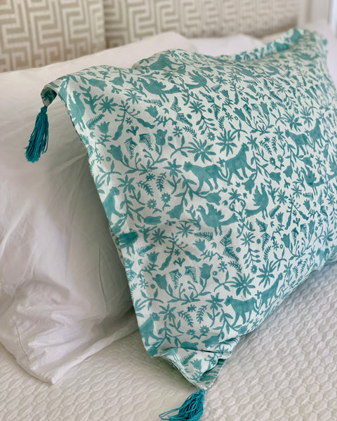 Aqua / sage blue and ice blue hand block-printed organic cotton linen jaguar print pillow sham with tassels on luxurious bed