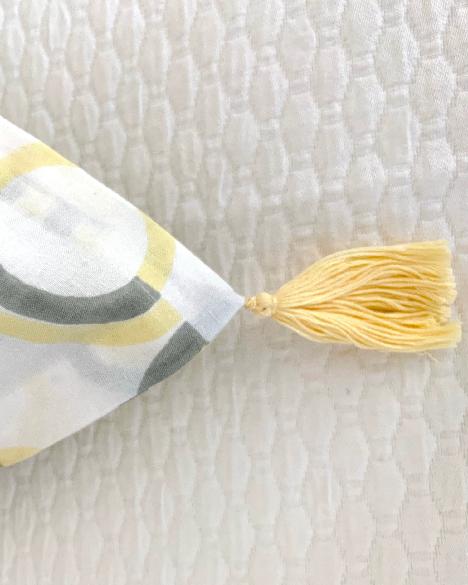 Close-up of organic cotton linen hand block-printed pillow sham yellow tassel