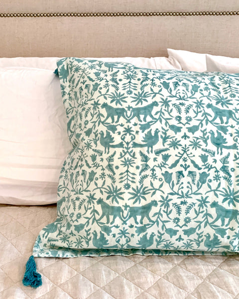 Aqua / sage blue and ice blue hand block-printed organic cotton linen jaguar print pillow sham with tassels on luxurious bed