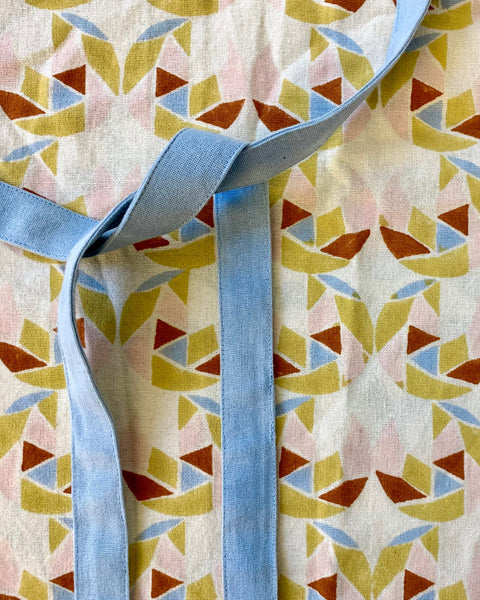 Close-up of a hand block-printed apron with adjustable ties and pockets