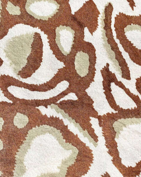 Close-up of rust, khaki, and white hand block-printed napkin 