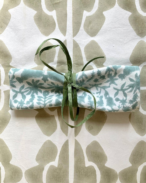 Rolled hand block-printed sage jaguar napkin on hand block-printed sand / khaki and cream table runner