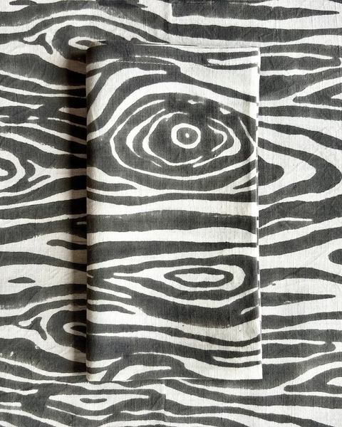 A gray and white faux bois hand block-printed organic cotton linen folded napkin and table runner 